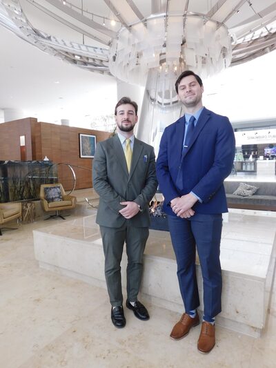 Two professionals in a modern hotel lobby