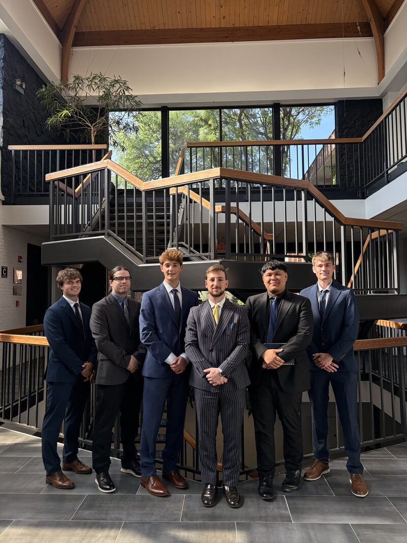 STLN Group team members in business attire gathered on a staircase